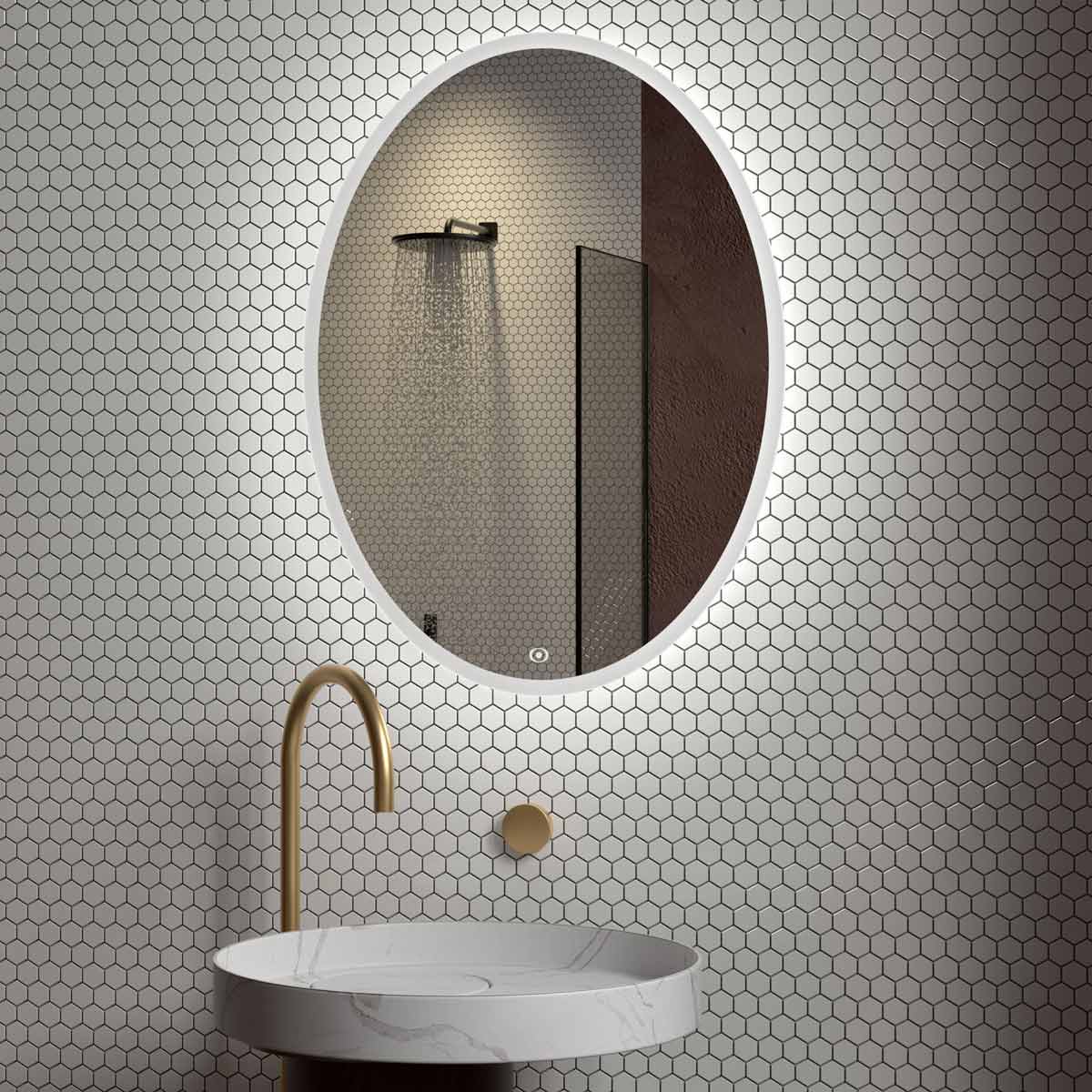 An oval mirror with a thin white LED light frame is mounted on a wall covered in white hexagonal tiles.