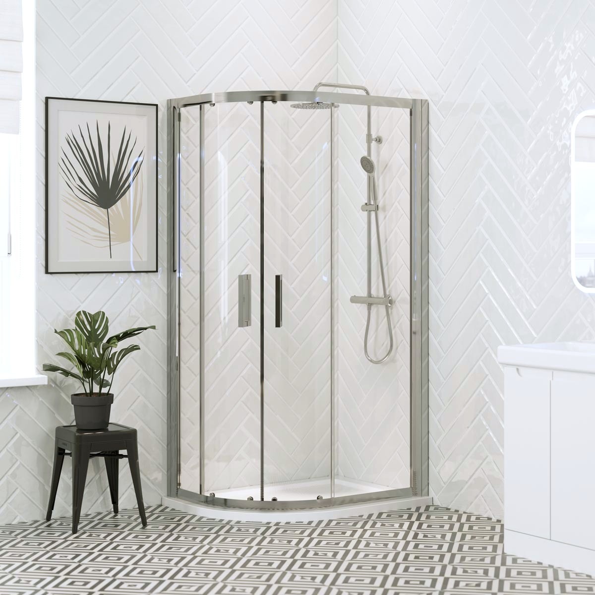 Chrome offset quadrant shower enclosure with sliding glass doors and white shower tray in a bright modern bathroom with white herringbone wall tiles.