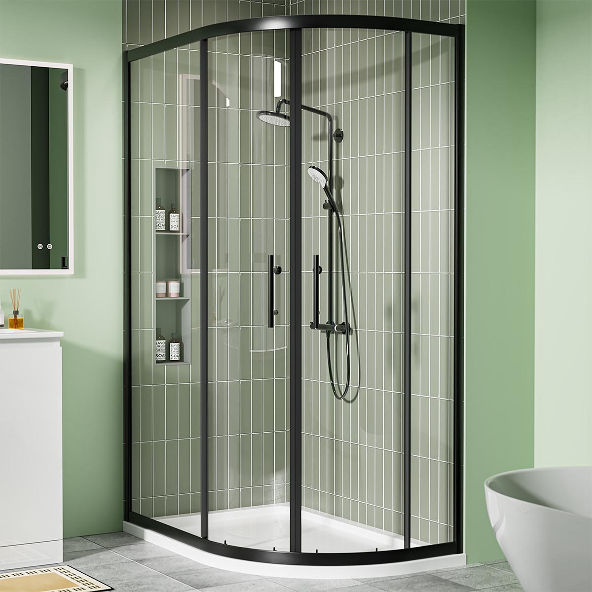 Matt black offset quadrant shower enclosure with sliding glass doors and white shower tray in a modern green-tiled bathroom.