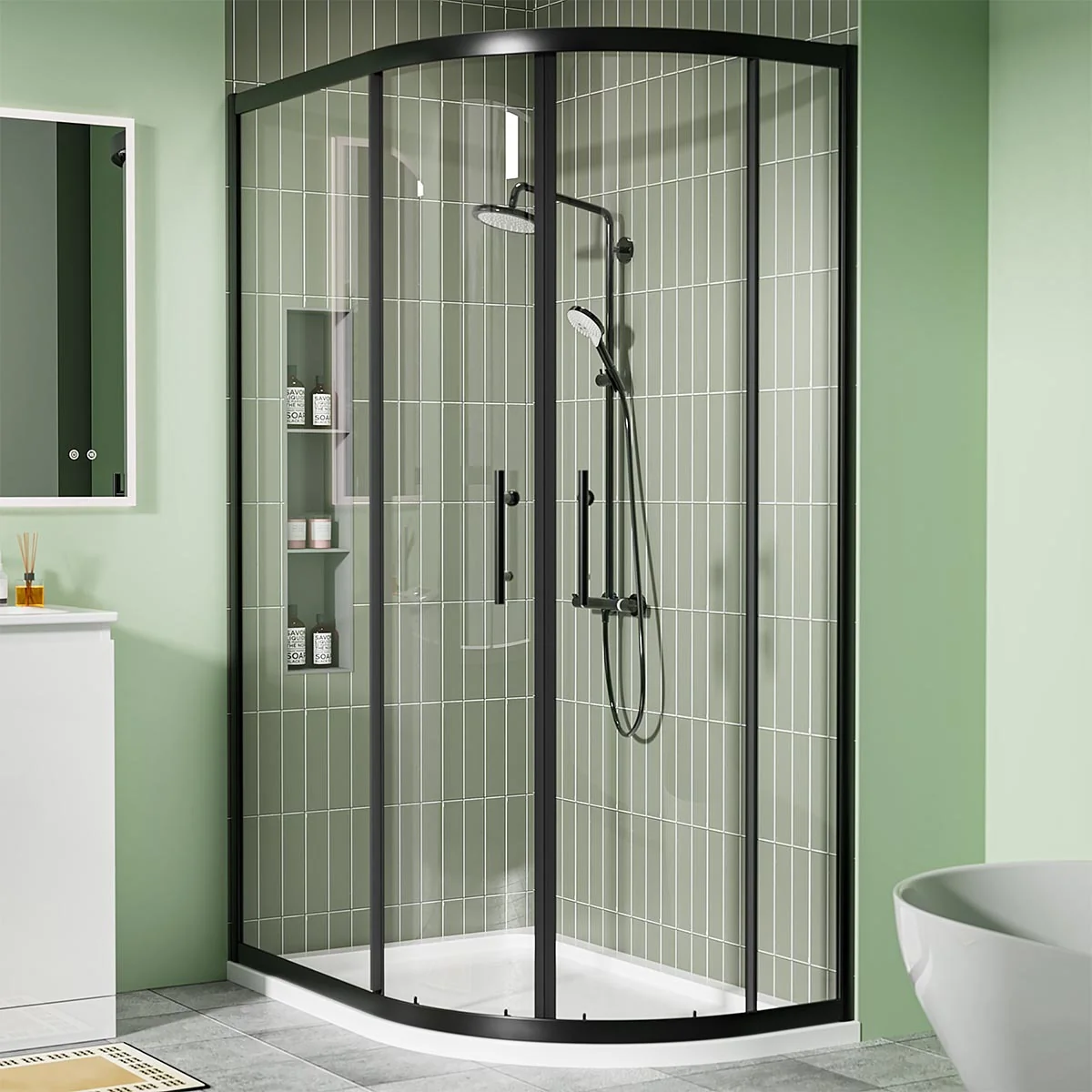 Matt black offset quadrant shower enclosure with sliding glass doors and white shower tray in a modern green-tiled bathroom.