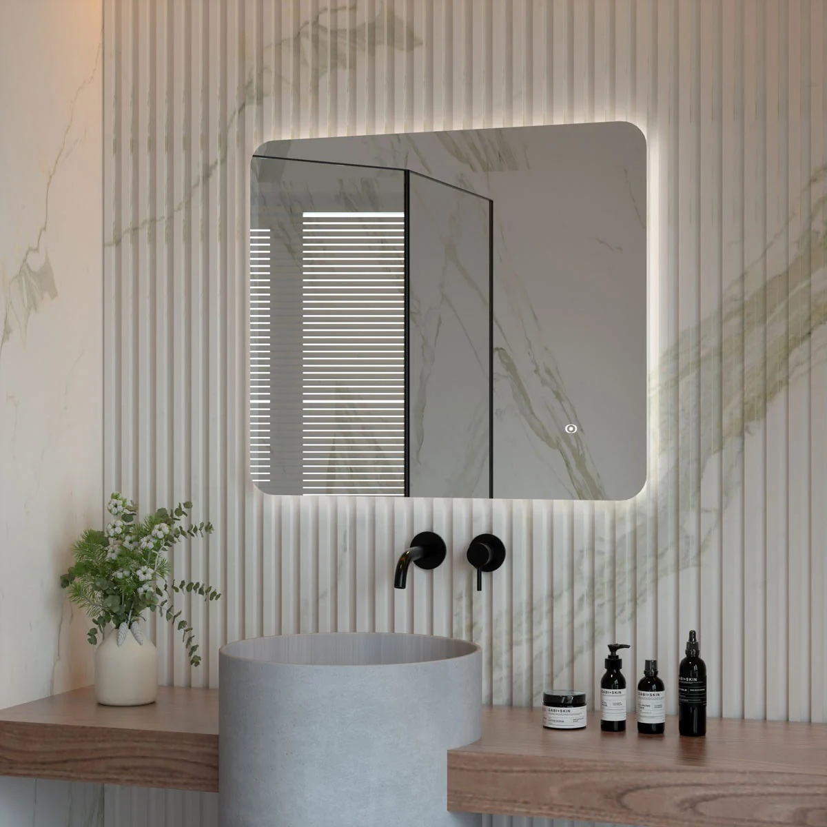 Modern rectangular LED illuminated bathroom mirror with a sleek ultra-slim design, soft backlit glow, and clean lines, mounted above a contemporary basin and surrounded by marble-textured walls.