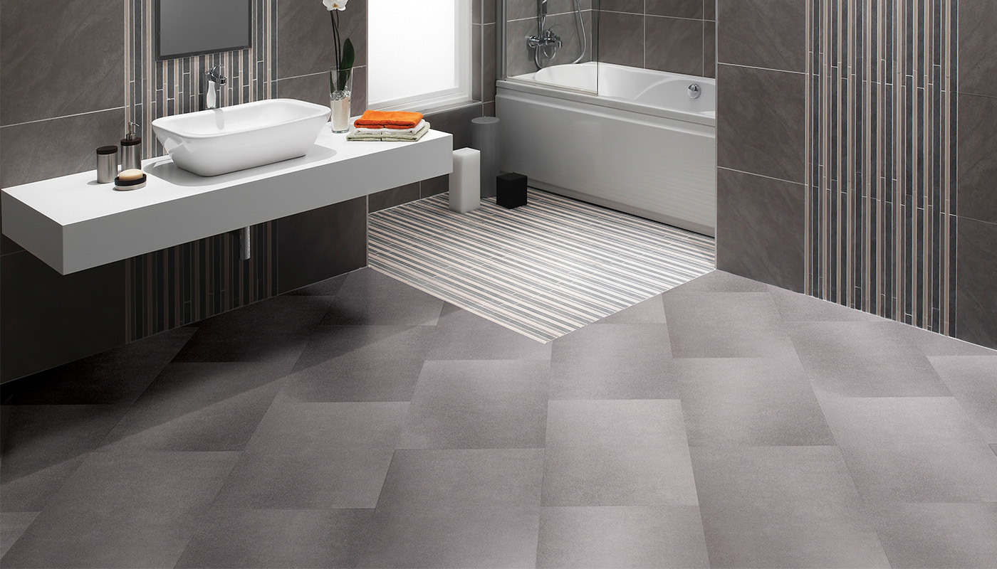 Modern grey bathroom with a white floating sink, chrome faucet, and striped accent wall near a white bathtub.