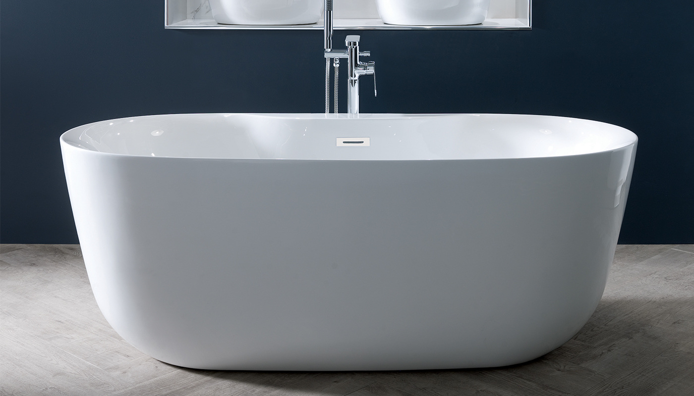 A white freestanding oval bathtub with a chrome faucet. The bathtub is placed on a gray tiled floor against a dark blue wall
